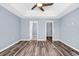 Bedroom featuring neutral paint, a tray ceiling, ceiling fan, vinyl flooring, and closet entrances at 389 Barton Loop, Myrtle Beach, SC 29579