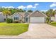 Charming single-story home with a well-manicured lawn, two-car garage, and palm trees at 389 Barton Loop, Myrtle Beach, SC 29579