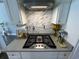 Close-up view of a gas stovetop with a pot filler and granite counters surrounded by white cabinetry at 4008 Tupelo Ct., Conway, SC 29526