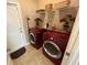 Convenient laundry room with modern red washer and dryer, storage shelves, and a folding area at 4008 Tupelo Ct., Conway, SC 29526