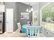 Bright dining area with a blue table, a chandelier, and a large window, creating a cozy and inviting space for meals at 404 Windermere Lake Circle, Conway, SC 29526