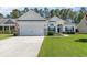 Charming single-story home featuring a well-manicured lawn and an attached two-car garage at 404 Windermere Lake Circle, Conway, SC 29526