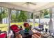 Relaxing screened porch with comfortable wicker furniture, ceiling fan and views of the green backyard and shed at 404 Windermere Lake Circle, Conway, SC 29526