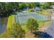 Aerial view of outdoor tennis and basketball courts, pool, and pond surrounded by trees in a beautiful community at 4276 Santolina Way # A, Murrells Inlet, SC 29576