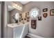 Well-lit bathroom with a white vanity, a large mirror, and an octagonal window at 4363 Parkland Dr., Myrtle Beach, SC 29579