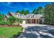 Charming brick home featuring a red door, dormer windows, lush landscaping and a curving driveway at 4363 Parkland Dr., Myrtle Beach, SC 29579
