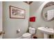 Charming powder room with a pedestal sink, decorative wallpaper and framed artwork creating a welcoming atmosphere at 4363 Parkland Dr., Myrtle Beach, SC 29579