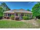 Brick home exterior with a screened porch, surrounded by a well-maintained lawn and lush landscaping at 4363 Parkland Dr., Myrtle Beach, SC 29579