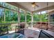 Relaxing screened porch with views of the wooded backyard, featuring comfortable seating and a ceiling fan at 4363 Parkland Dr., Myrtle Beach, SC 29579
