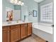 The bathroom offers a double sink vanity with tile floor, wood cabinets, and a standalone tub under a glass block window at 442 Mahogany Dr. # 101, Murrells Inlet, SC 29576