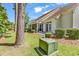 Rear exterior view of home featuring a screened in porch, lush landscaping, and a well maintained lawn at 442 Mahogany Dr. # 101, Murrells Inlet, SC 29576