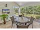 Cozy screened-in porch with tile flooring, a table with chairs, and beautiful backyard views at 442 Mahogany Dr. # 101, Murrells Inlet, SC 29576
