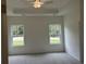 Bright bedroom featuring plush carpet, a ceiling fan, and ample natural light from two windows at 4762 Huckleberry Ln., Conway, SC 29526
