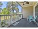 Relax on this cozy porch with a ceiling fan, peaceful golf course view, and comfortable seating at 4771 Wild Iris Dr. # 103, Myrtle Beach, SC 29577
