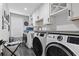 Modern laundry room with white cabinets, stainless steel sink, and front-loading washer and dryer at 4862 Mill Pond Rd., Myrtle Beach, SC 29588