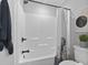 Clean white shower featuring matte black hardware, built-in shelves, and a decorative shower curtain at 4862 Mill Pond Rd., Myrtle Beach, SC 29588