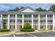 Attractive condo building featuring classic white pillars, multiple balconies and a landscaped walkway entrance at 5000 Windsor Green Way # 102, Myrtle Beach, SC 29579