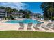 Beautiful community pool surrounded by lounge chairs and lush landscaping at 5000 Windsor Green Way # 102, Myrtle Beach, SC 29579