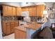Kitchen with wooden cabinets, white appliances, mosaic backsplash, and a bar counter extending to the living room at 501 44Th Ave. N # D 9, Myrtle Beach, SC 29577