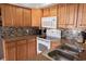 Bright kitchen showcasing wooden cabinets, modern white appliances, mosaic backsplash, and stainless steel sink at 501 44Th Ave. N # D 9, Myrtle Beach, SC 29577