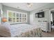 Bright bedroom featuring shuttered windows, beach-themed decor, and a ceiling fan for added comfort at 5801 Oyster Catcher Dr. # 1214, North Myrtle Beach, SC 29582