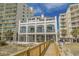 Exterior view of a beachfront property with multiple floors, balconies, and boardwalk access at 5801 Oyster Catcher Dr. # 1214, North Myrtle Beach, SC 29582