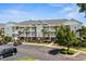 Attractive condo complex featuring palm trees, a gray color palette and ample parking at 5801 Oyster Catcher Dr. # 1214, North Myrtle Beach, SC 29582