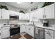 Well-lit kitchen boasts white cabinets, stainless appliances, and modern fixtures at 5801 Oyster Catcher Dr. # 1214, North Myrtle Beach, SC 29582