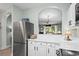 Kitchen showcasing stainless steel refrigerator, white cabinets, quartz countertops, and open layout at 5801 Oyster Catcher Dr. # 1214, North Myrtle Beach, SC 29582