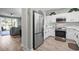 Bright kitchen with stainless steel refrigerator, white cabinets, and an open view to the living room at 5801 Oyster Catcher Dr. # 1214, North Myrtle Beach, SC 29582