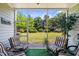 Relaxing screened porch featuring striped chairs with views of the manicured lawn and landscape at 5801 Oyster Catcher Dr. # 1214, North Myrtle Beach, SC 29582