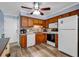 Well-equipped kitchen with wood cabinetry, white appliances, and stone backsplash at 6000 N North Ocean Blvd. # 329, North Myrtle Beach, SC 29582