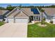 Inviting home featuring a well-manicured lawn, attached two-car garage and solar panels at 757 Cherry Blossom Dr., Murrells Inlet, SC 29576
