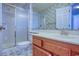Bathroom with glass shower, floral wallpaper, wooden vanity, and tile floors at 802 Mockingbird Ct., Murrells Inlet, SC 29576