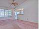 Living room view with vaulted ceiling, pink carpet, and view of the screened porch at 802 Mockingbird Ct., Murrells Inlet, SC 29576