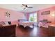 Pink bedroom with wood floors, window view and comfortable sitting area at 8029 Wacobee Dr., Myrtle Beach, SC 29579