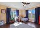 This cheerful bedroom features wood floors, ceiling fan, and large windows with neighborhood views at 8029 Wacobee Dr., Myrtle Beach, SC 29579