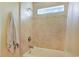 This tiled shower boasts a neutral color palette and small window at 8029 Wacobee Dr., Myrtle Beach, SC 29579