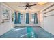 Bright sunroom with multiple windows, blue curtains, and a ceiling fan at 844 Wachesaw Rd., Murrells Inlet, SC 29576