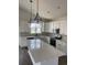 Bright kitchen featuring white cabinets, a large center island, stainless steel appliances, and modern pendant lighting at 905 Inlet Keys St., Murrells Inlet, SC 29576