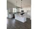 Bright kitchen featuring white cabinets, a large center island, stainless steel appliances, and modern pendant lighting at 905 Inlet Keys St., Murrells Inlet, SC 29576