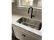 Close-up of stainless steel sink, black faucet, and white quartz countertops with modern tiled backsplash at 905 Inlet Keys St., Murrells Inlet, SC 29576