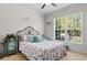 Bright bedroom featuring a bed, ceiling fan, large window, and nautical decor at 9060 Abingdon Dr., Myrtle Beach, SC 29579