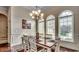 Open dining area with hardwood floors, a chandelier, three arched windows and a view into the home's entry at 9060 Abingdon Dr., Myrtle Beach, SC 29579