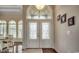 An entryway with decorative glass doors, a transom window, and dark hardwood floors offers an inviting introduction to the home at 9060 Abingdon Dr., Myrtle Beach, SC 29579