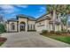 Stunning home featuring a symmetrical elevation, arched windows and entrance, attached garage, palm trees, and a spacious driveway at 9060 Abingdon Dr., Myrtle Beach, SC 29579