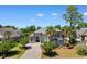 An elevated home with lush landscaping and a grand entrance is surrounded by mature trees and a long driveway at 9060 Abingdon Dr., Myrtle Beach, SC 29579
