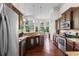 A kitchen with wooden cabinets, granite countertops, hardwood floors, and natural light from the bay windows at 9060 Abingdon Dr., Myrtle Beach, SC 29579