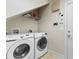 Functional laundry room with a washer, dryer, storage shelf, and neutral colors at 9060 Abingdon Dr., Myrtle Beach, SC 29579