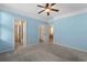 Spacious blue bedroom featuring two closets, a ceiling fan, and access to an en suite bathroom at 908 Oglethorpe Dr., Conway, SC 29527